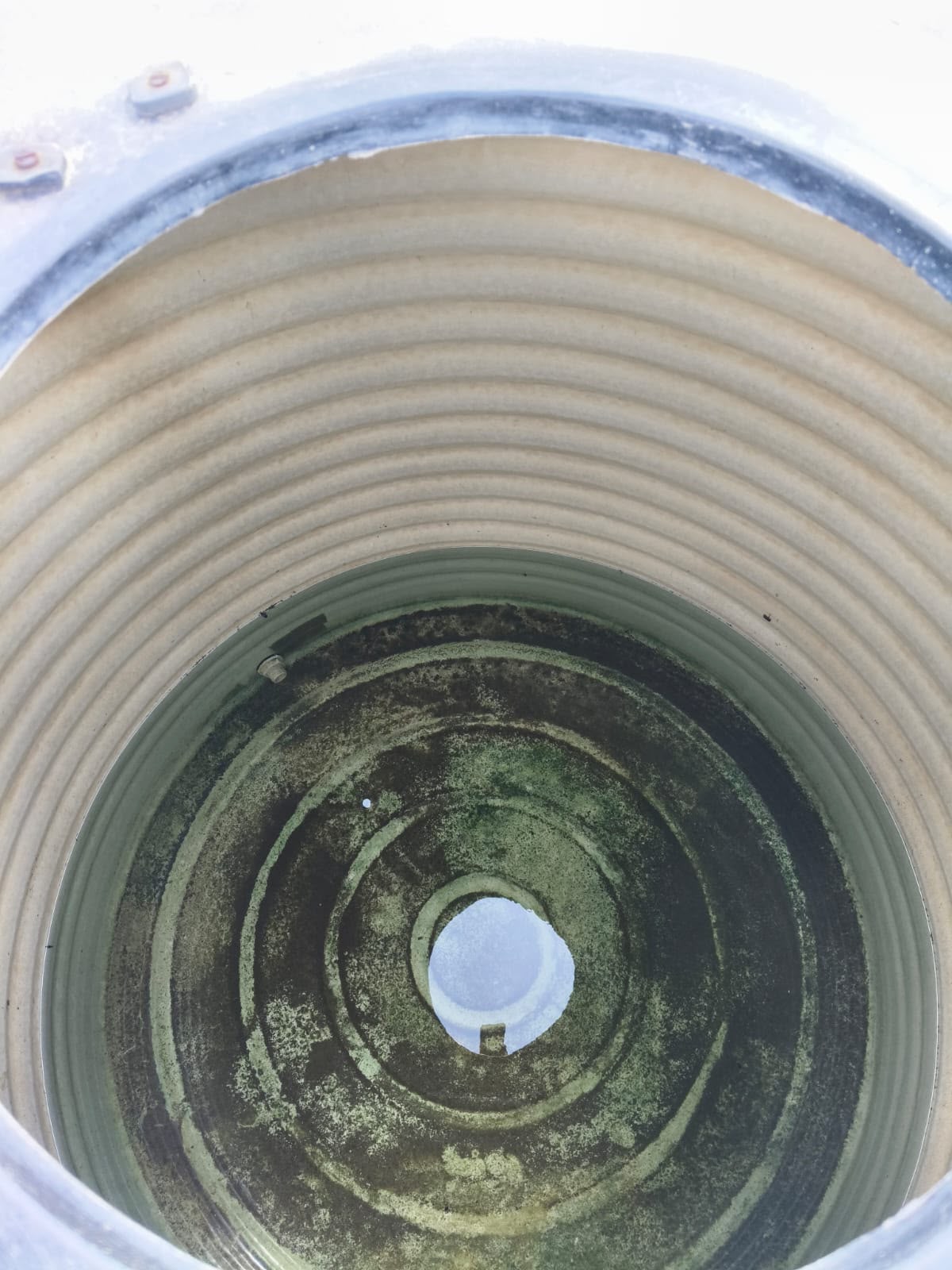 Dirty plastic water tank interior with accumulated deposits
